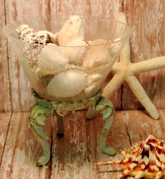 Seashell Filled Glass Container On Metal Stand