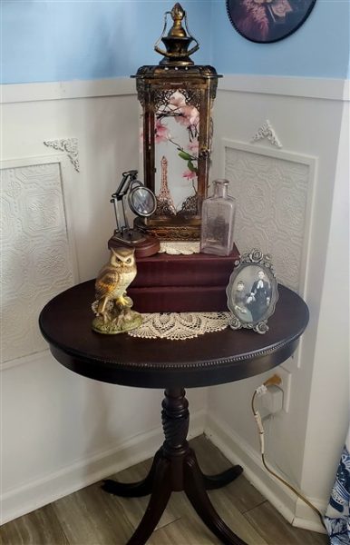 thrifted antique end table decorated with books and old decor for home library
