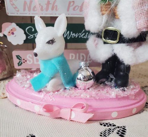 One-of-a-kind pink Santa Christmas diorama with retro reindeer, wooden North Pole sign and faux snow on a pink base