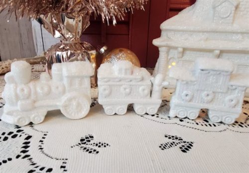 White glittered ceramic Christmas village train station with electric light and three-piece train set