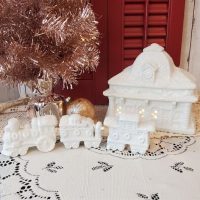 White glittered ceramic Christmas village train station with electric light and three-piece train set