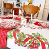 Vintage mid-century holiday table linen displayed on a dining table with classic red and green Christmas print.