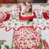 Vintage mid-century holiday table linen displayed on a dining table with classic red and green Christmas print.